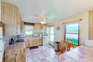 a kitchen with wooden cabinets and a table and chairs at The Summer House in Onekama +13 photos