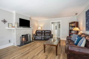 a living room with leather furniture and a fireplace at Serenity Now in Saugatuck