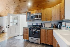 a kitchen with wooden cabinets and a stove at Fresh Pond Chateau in Oak Bluffs +13 photos