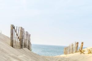 a fence on a beach next to the ocean at Paul Revere in Provincetown