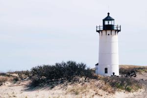 a lighthouse sitting on top of a sandy beach at Paul Revere in Provincetown