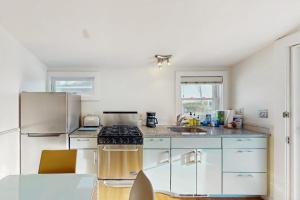 a kitchen with white cabinets and a stove top oven at Bayside Breeze in Truro