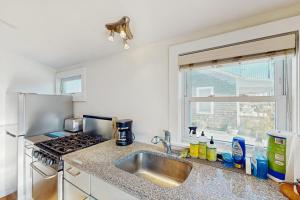 a kitchen with a sink and a stove and a window at Bayside Breeze in Truro