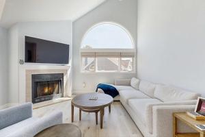 a living room with a white couch and a fireplace at Fairway Bliss at Ocean Edge in Brewster