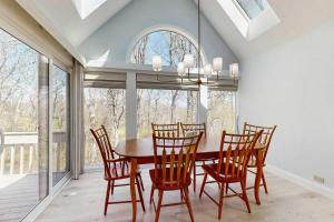 a dining room with a wooden table and chairs at Fairway Bliss at Ocean Edge in Brewster