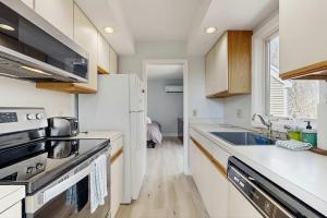 a kitchen with a white refrigerator and a sink at Fairway Bliss at Ocean Edge in Brewster +38 photos