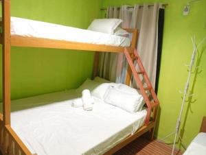 two bunk beds in a room with green walls at Jaliha Homestay in San Isidro +6 photos