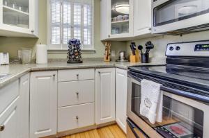 a kitchen with white cabinets and an oven at Island Sanctuary in Oak Bluffs