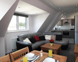 a living room with a couch and a table at Austens Apartments in Torquay