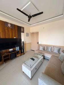 a living room with a couch and a flat screen tv at Cloud Nine in Boria Kalān