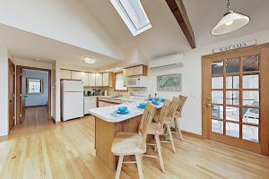 a kitchen with a table and chairs and a refrigerator at Harbor Cove Cottage in Edgartown