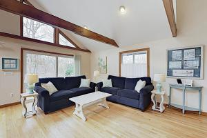 a living room with two couches and a table at Harbor Cove Cottage in Edgartown