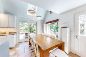 a kitchen with a wooden table and white cabinets at Osprey View Villa in Dennis