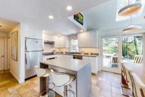 a kitchen with white appliances and a table with chairs at Osprey View Villa in Dennis