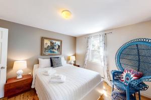 a bedroom with a bed and a blue chair at Osprey View Villa in Dennis