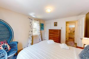 a bedroom with a white bed and a blue chair at Osprey View Villa in Dennis +13 photos