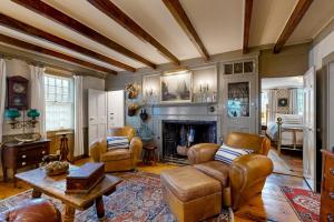 a living room with leather furniture and a fireplace at The Groggy Anchor in Provincetown