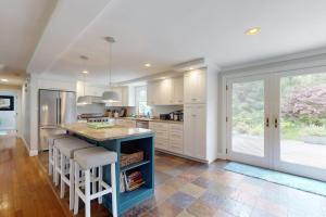 a kitchen with a blue island with bar stools at Bumps River Bungalow in Centerville