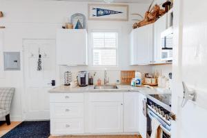 a white kitchen with white cabinets and a sink at Long Point Getaway in Provincetown