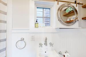 a white bathroom with a sink and a mirror at Long Point Getaway in Provincetown