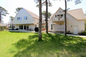 a large white house with a tree in the yard at Blackfish Bungalow in Wellfleet