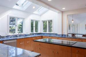 a large kitchen with a sink and windows at Blackfish Bungalow in Wellfleet +36 photos