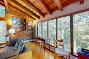 a living room with a couch and a table and some windows at Old Kings Hideout in Wellfleet