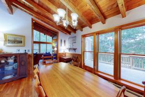a dining room with a large wooden table and windows at Old Kings Hideout in Wellfleet +31 photos
