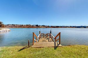 a wooden dock sitting on the side of a lake at Island Bay Bungalow in Eastham