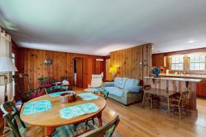 a living room with a table and a couch at Pickerel Cove Cottage in Mashpee