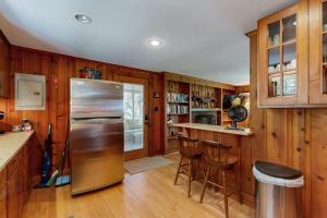 a kitchen with a stainless steel refrigerator and wooden walls at Pickerel Cove Cottage in Mashpee