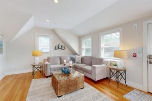 a living room with a couch and a table at Oyster Beach Bungalow in Chatham