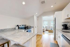 a kitchen with white cabinets and a large counter top at Oyster Beach Bungalow in Chatham