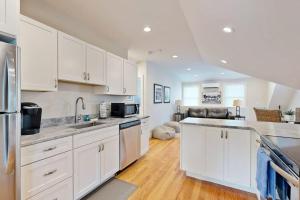 a kitchen with white cabinets and a counter top at Oyster Beach Bungalow in Chatham +17 photos