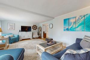 a living room with a blue couch and a tv at Namskaket Retreat in Orleans