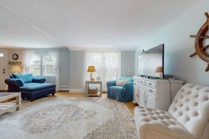 a living room with blue furniture and a tv at Namskaket Retreat in Orleans