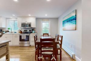 a kitchen with a table and chairs in a room at Namskaket Retreat in Orleans