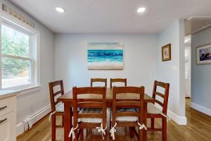 a dining room with a table and four chairs at Namskaket Retreat in Orleans