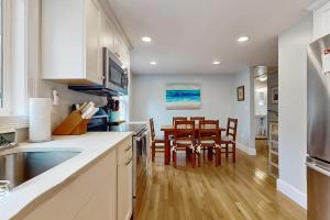 a kitchen with white cabinets and a table and chairs at Namskaket Retreat in Orleans +16 photos