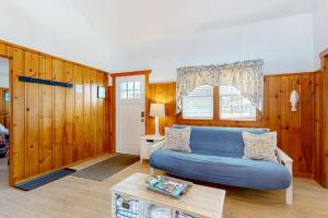 a living room with a blue couch and a window at Trotting Park Paradise in West Dennis