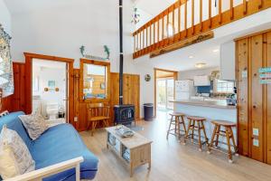 a living room with a blue couch and a kitchen at Trotting Park Paradise in West Dennis