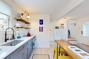 a kitchen with blue cabinets and a white refrigerator at Long Pier Lodge in Provincetown