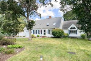 a white house with a tree and a yard at Moon Compass Manor in Sandwich