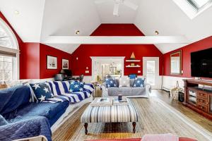 a living room with red walls and blue couches at Moon Compass Manor in Sandwich
