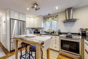 a kitchen with white cabinets and a table with stools at Moon Compass Manor in Sandwich +25 photos