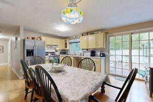 a kitchen with a table and chairs and a kitchen with yellow cabinets at Lobster Rock Retreat in Barnstable