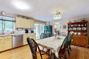 a kitchen with a table and chairs and a kitchen with a table and a table at Lobster Rock Retreat in Barnstable