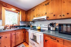a kitchen with wooden cabinets and a white stove top oven at Pretty on Prada in Edgartown