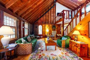 a living room with a green couch and wooden ceilings at Pretty on Prada in Edgartown