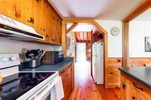 a kitchen with wooden cabinets and a white refrigerator at Pretty on Prada in Edgartown